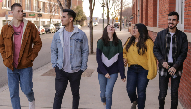 A group of teens walking on a side walk